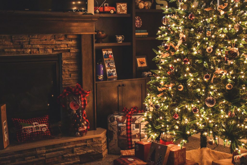 Christmas tree next to a fire place