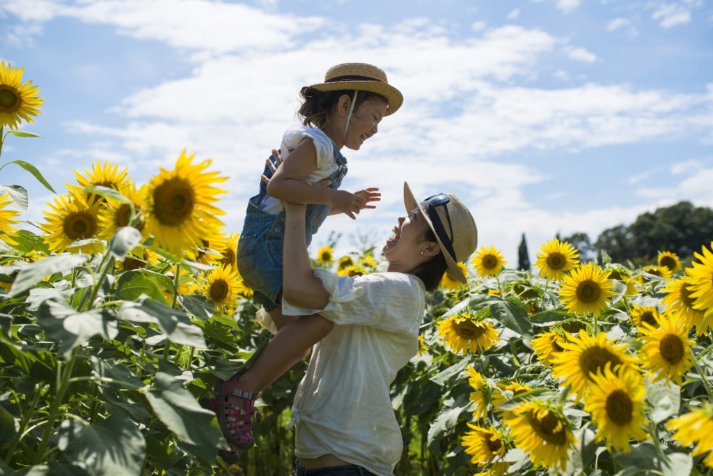 Mother and daughter playing in a sunflower field