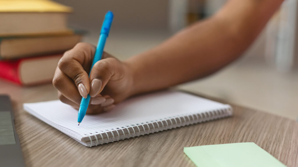 African american girl making notes in notebook