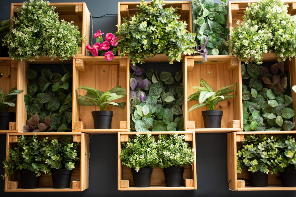 A view of a wooden wall mount design filled with an array of plastic indoor plants.