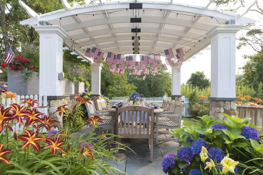 Festive Fourth of July party table set under garden pergola