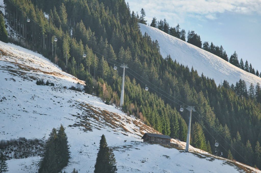 Ski Lifts Up A Steep Snowy Hill Hear Evergreen Trees and Mountains